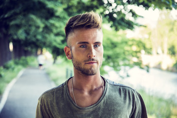 Fototapeta premium Good looking, blue eyed male model relaxing in nature, walking, looking to a side