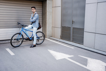 Confident smiling male person sitting at bike