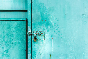 close up on green door with the key locked, abstract background with vintage filter. to show the old texture on metallic.