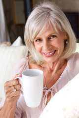 older woman smiling with cup of coffee