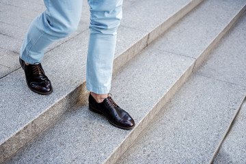 Active stylish male person going on steps