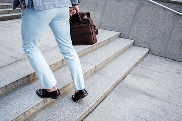 Active elegant male person overcoming stairs