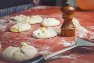 Pepper grinder, spatula and dough noudles on a table