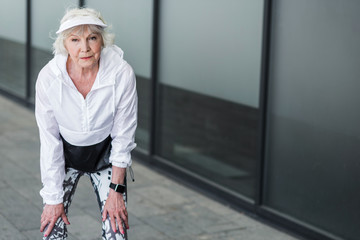 Thoughtful elderly woman having break time while exercising outdoors