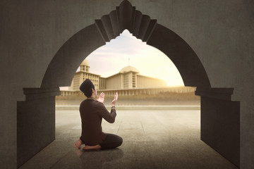 Rear view of asian muslim man praying to god