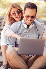 Young couple in summer park listening music