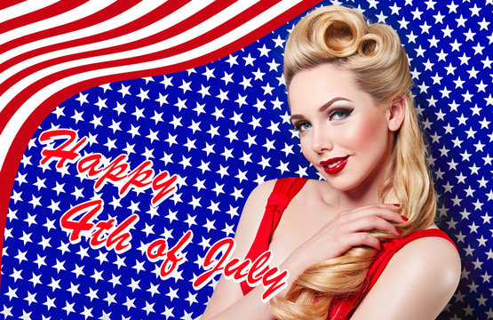 Holiday US Independence Day, the fourth of July. Beautiful young girl in retro style smiling on the background of the American flag. The blonde pinup. Postcard, advertising. Hair curls, red lips.