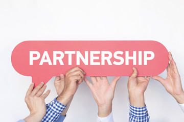 Group of people holding the PARTNERSHIP written speech bubble