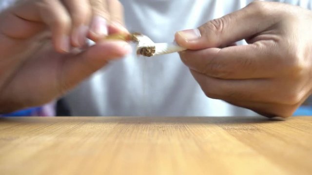 Man hands breaking cigarette, closeup