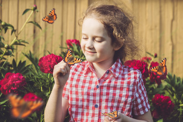 Curly girl with a butterfly on his finger.