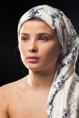 Portrait of young woman wearing a headscarf on black background in studio photo