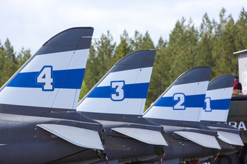 Jet fighter tails on the air base. Numbered tail wings on the airfield. 