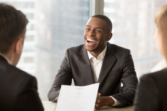 Happy black successful candidate getting hired, cheerful african applicant with beaming smile got a dream job in big company, dark-skinned businessman excited by great news, startupper found investor