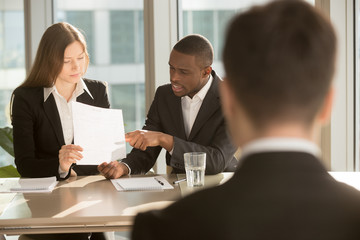Multiracial employers or recruiters making hiring decision, discussing resume while job applicant waiting for result, employee selection team considering candidate cv before after personal interview