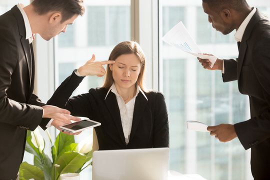 Overworked tired businesswoman puts finger gun to head, stressed with too much hard work, multitasking female boss wants to quit showing figurative gesture killing herself, exhausted of difficult job