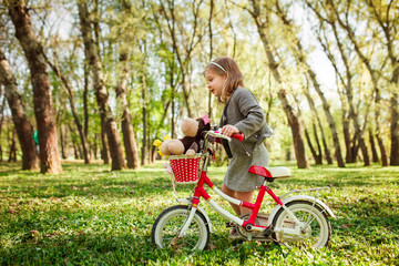 Fototapeta na wymiar Little girl with cycle in park