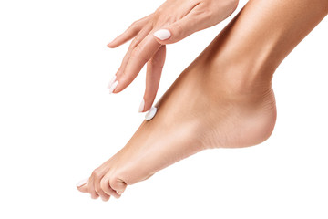 Woman applying cream on her beautiful feet.