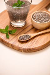 Selective focus of chia seeds drink with water in transparent glass with lemon balm.