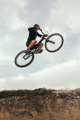 Man in moment of jumping on bike © kegfire