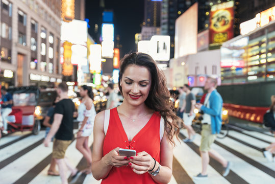 Beautiful woman using phone in Times Square.