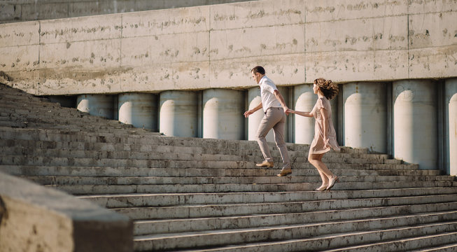 A Beautiful Couple, A Girl With A Guy In Summer Clothes, Dress Beige, Running Up The Stairs