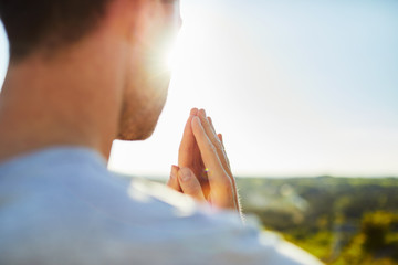 Closeup of man meditating, praying outdoors