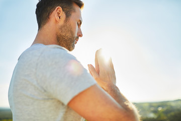 Adult man meditating, praying outdoors. Joga exercise outdoors