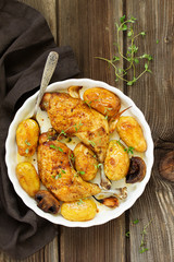 Baked chicken thigh with potatoes and vegetables.