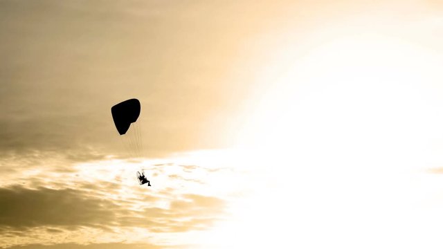 Parachute or paramotor fly in sunset,Black shadow, sport activity, UHD 4k 3840x2160.
