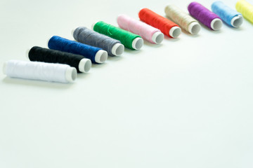 Spools of colours threads or call yarns on rolls for sewing isolated on white background