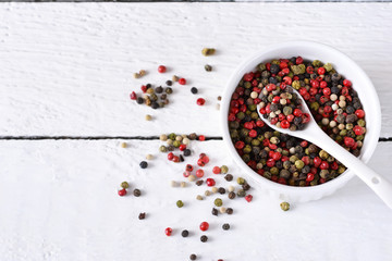 Food background with spices. A mixture of bell peppers on a white wooden background. Top view.