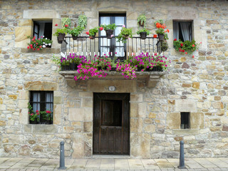 Fototapeta na wymiar Fachada de casa rural con balcón decorado