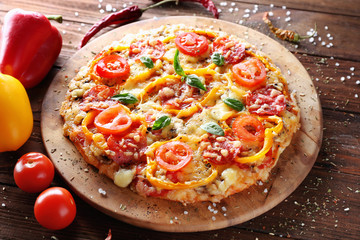 Composition of tasty pizza, vegetables and spices on wooden table