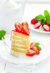 A piece of sponge cake with strawberries and cream.