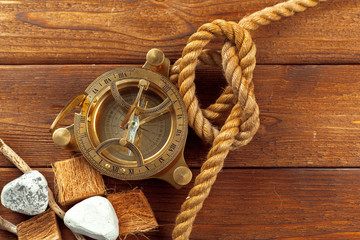 Compass and rope on wooden table. close up