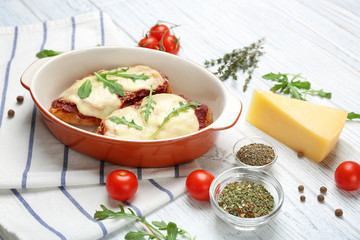 Chicken parmesan with spices in baking dish on table