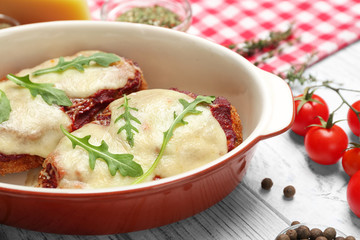Chicken parmesan with spices in baking dish on table