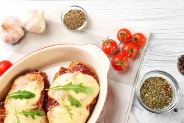 Chicken parmesan with spices in baking dish on table