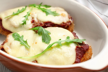Chicken parmesan with spices in baking dish, closeup