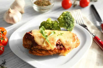 Tasty chicken parmesan with broccoli on plate