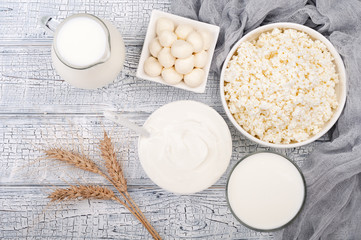 Dairy products on wooden table. Milk, sour cream, cheese, curd, wheat and yogurt. Farmers products. Healthy eating and diet concept. Top view