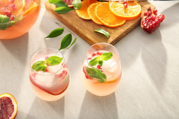 Two glasses of fresh cocktail with pomegranate and orange on table