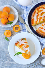 Homemade cake with apricots and nectarines on a concrete background.