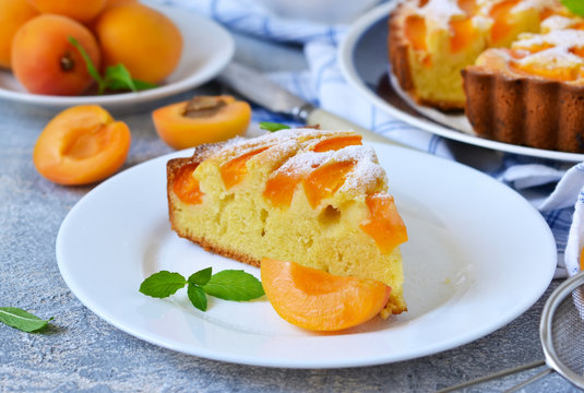 Homemade cake with apricots and nectarines on a concrete background.