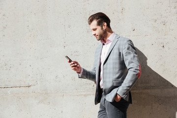 Portrait of a happy man in jacket holding mobile phone