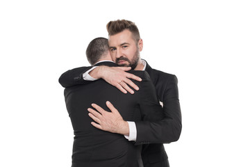 homosexual couple of grooms in suits hugging isolated on white