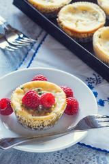 Passionfruit Mini Baked Cheesecakes with Raspberries on Table