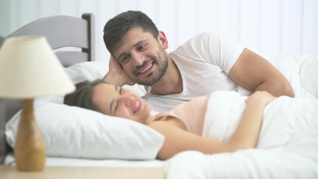 The happy couple kissing in the bed