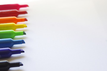 Rainbow colored marker tips on white background