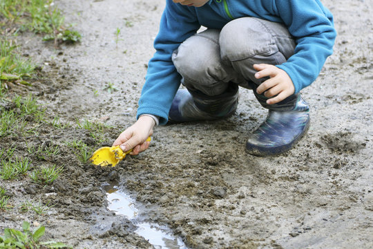 A Child Plays In The Dirt.